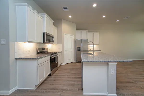 a large kitchen with a large counter top appliances and cabinets