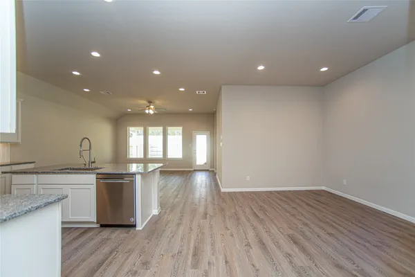 a kitchen with stainless steel appliances granite countertop a sink cabinets and wooden floor