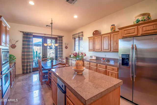 a kitchen with stainless steel appliances granite countertop a sink a stove and refrigerator