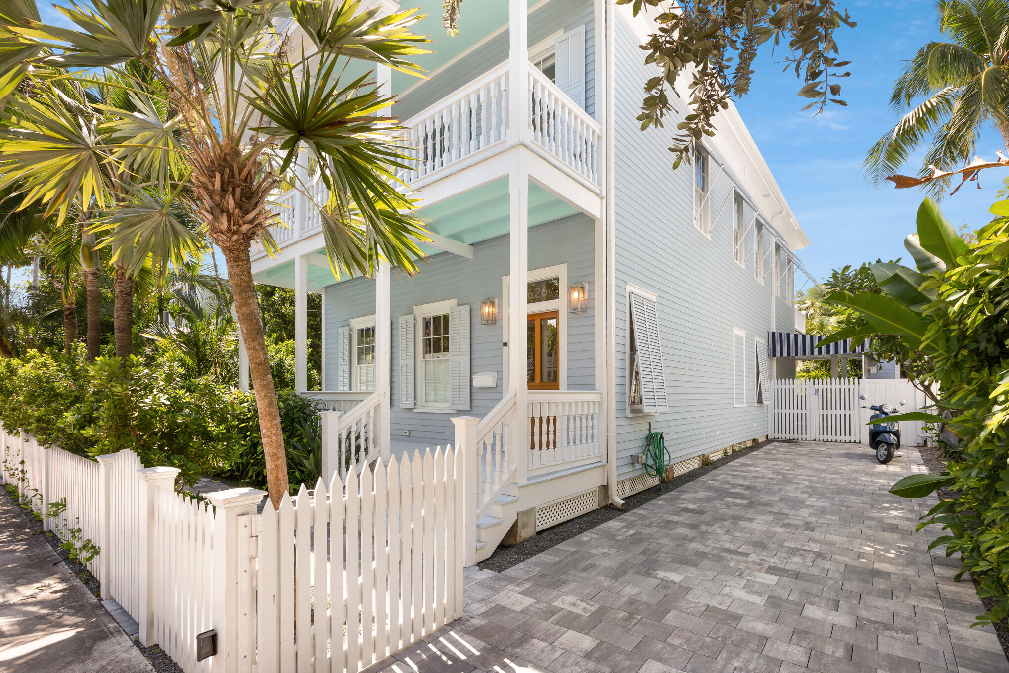 626 William Street Key West, FL 33040 - Photo 2 of 68 a view of a white house with large trees and wooden fence