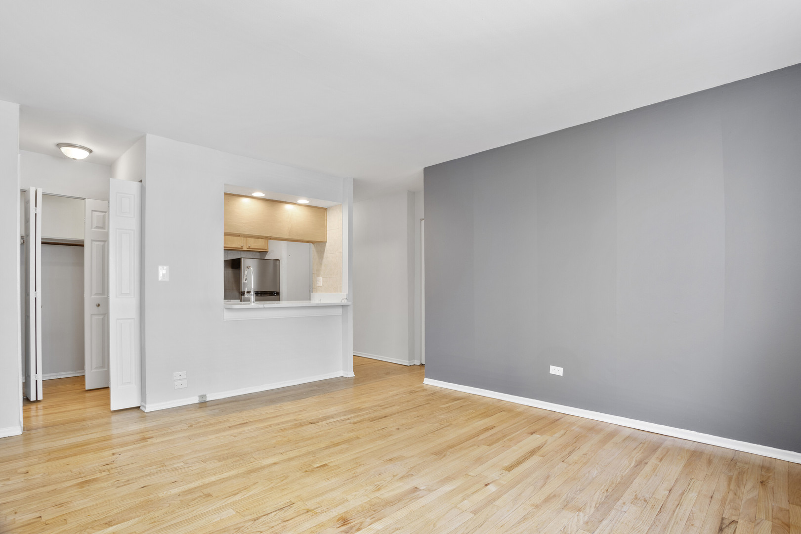 6758 North Sheridan Road, Unit 438 Chicago, IL 60626 - Photo 6 of 12 a view of an empty room with wooden floor and a window