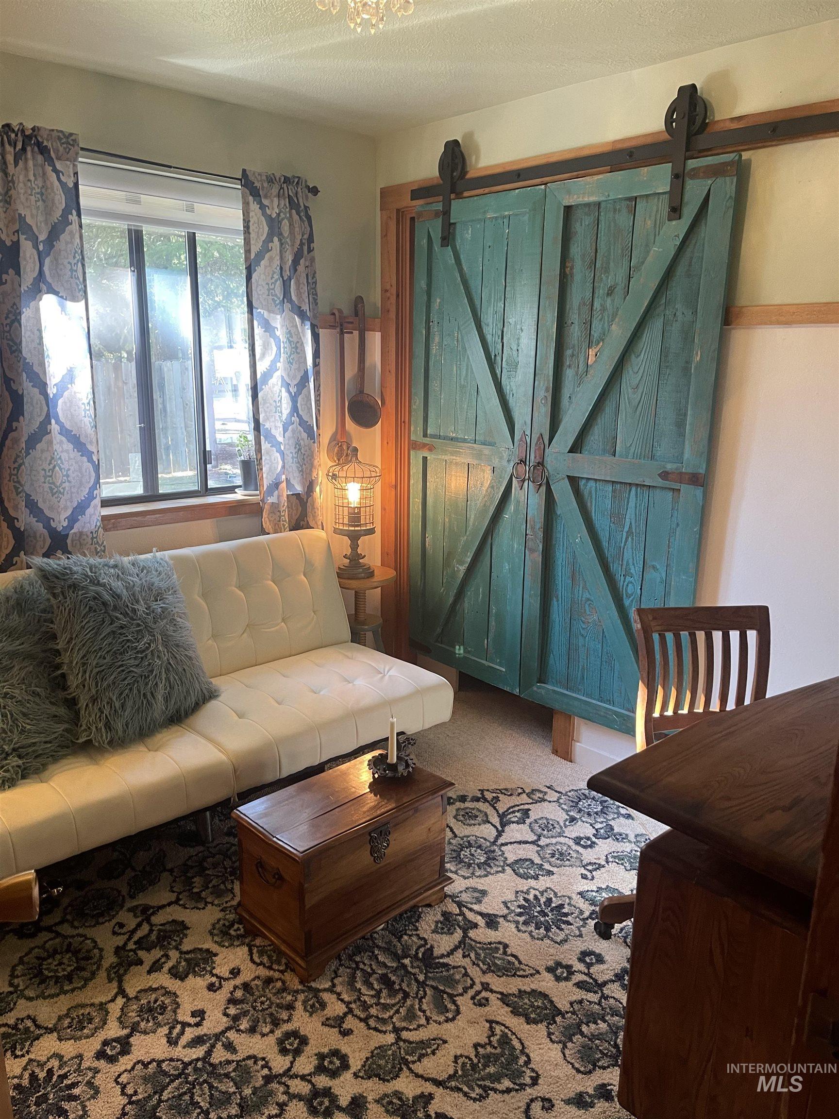 306 Rio Vista Boulevard McCall, ID 83638 - Photo 24 of 40 Living area with a textured ceiling, carpet flooring, and a barn door