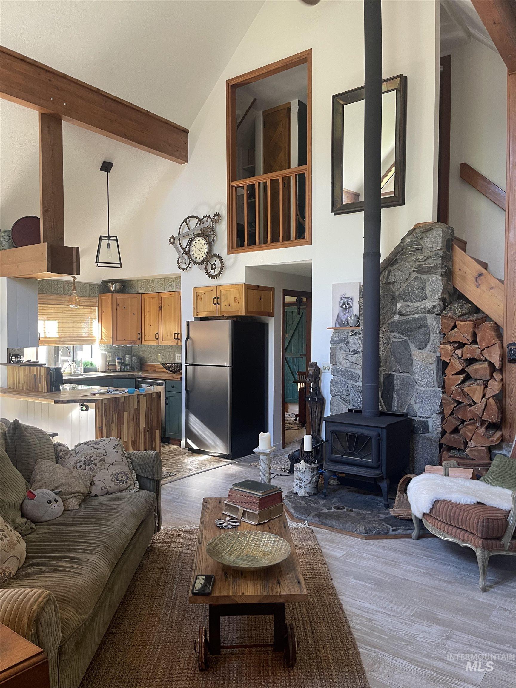 306 Rio Vista Boulevard McCall, ID 83638 - Photo 10 of 40 Living room featuring a wood stove, high vaulted ceiling, light wood finished floors, and beamed ceiling