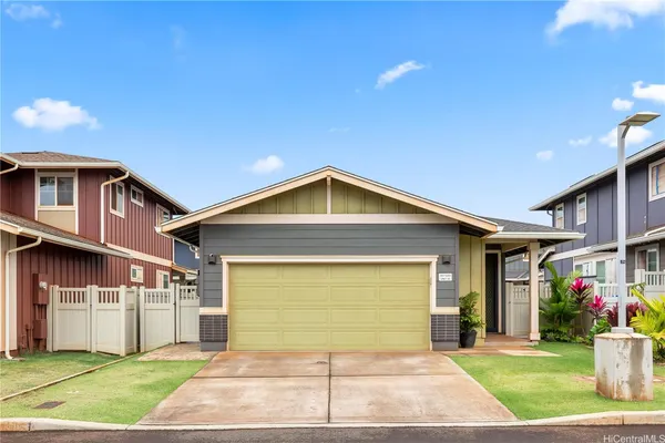 a front view of a house with a yard and potted plants