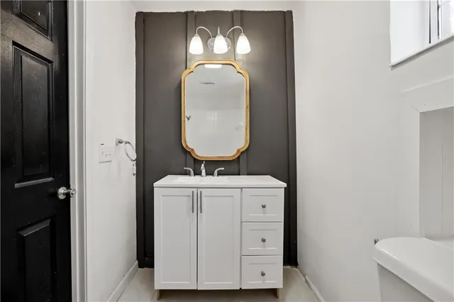 a bathroom with a toilet sink and mirror