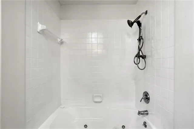 a bathroom with a bath tub with a shower