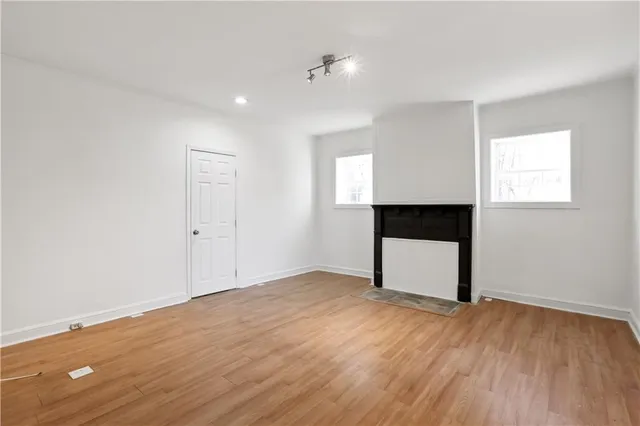 a view of empty room with wooden floor