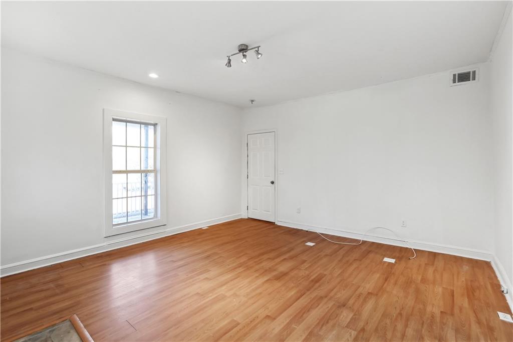 1512 Flat Shoals Road Atlanta, GA 30349 - Photo 10 of 35 an empty room with wooden floor and windows