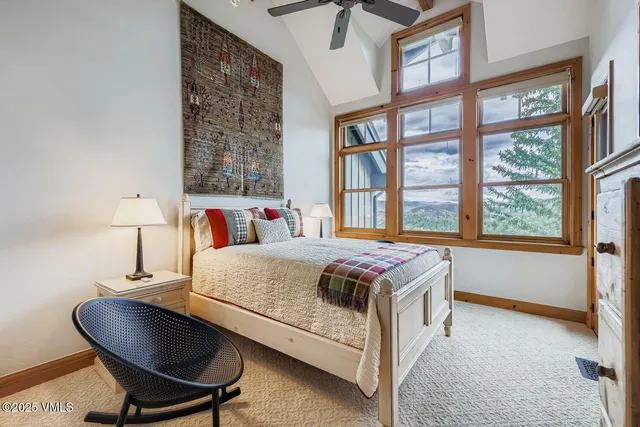 a bedroom with a bed and a table in it next to a window