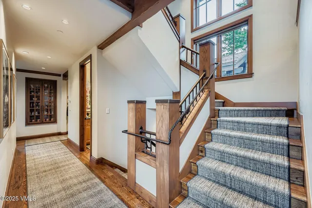 a view of staircase with lots of frames on wall and a window