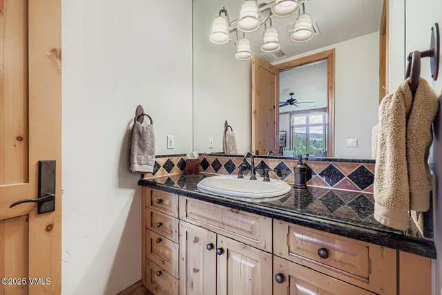 a bathroom with a sink vanity granite and a mirror