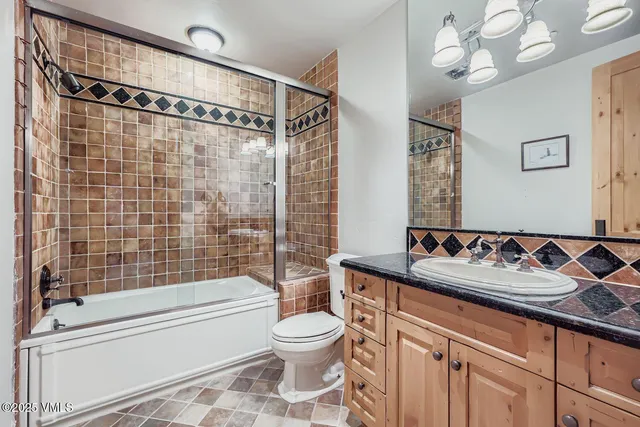 a bathroom with a granite countertop sink mirror vanity and toilet