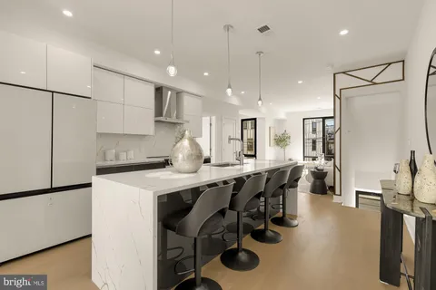 a kitchen with stainless steel appliances granite countertop a sink a refrigerator and a stove top oven with wooden floor