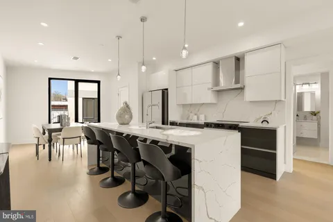 a kitchen with stainless steel appliances granite countertop a table chairs stove a sink dishwasher and cabinets with wooden floor