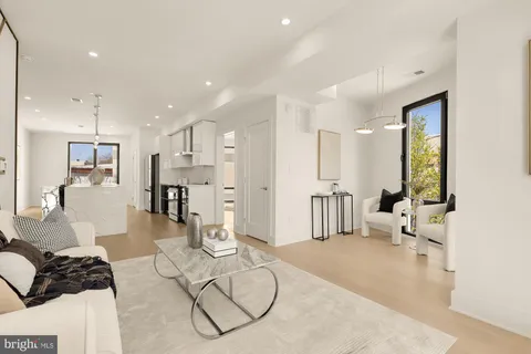 a living room with furniture a rug and kitchen view