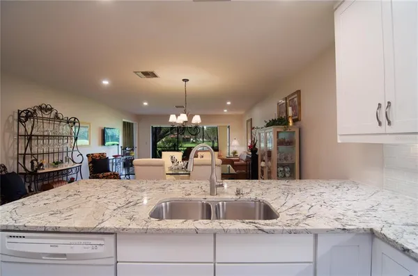 a kitchen with kitchen island granite countertop a large counter top cabinets and appliances