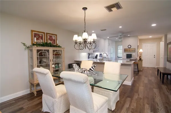 a living room with furniture a dining table and a chandelier
