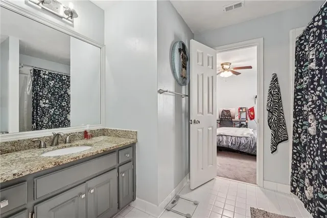 a en suite bathroom with a granite countertop tub sink and mirror