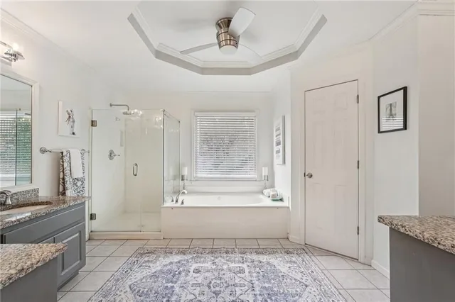 a bathroom with a granite countertop sink a mirror and a bathtub