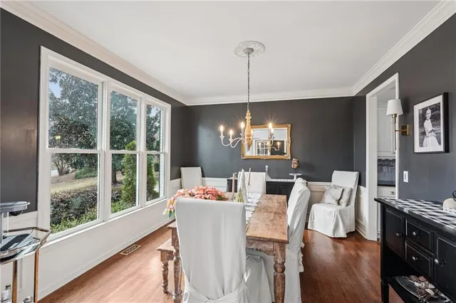 a view of a dining room with furniture a chandelier and wooden floor