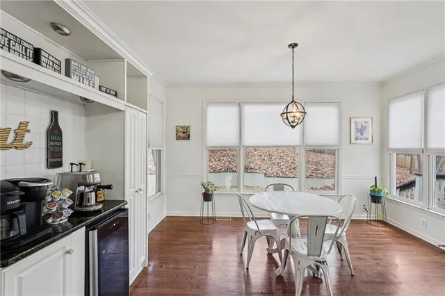a view of a dining room and livingroom with furniture wooden floor a chandelier