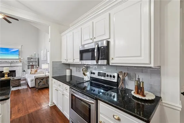 a kitchen with stainless steel appliances granite countertop a stove a sink and a microwave