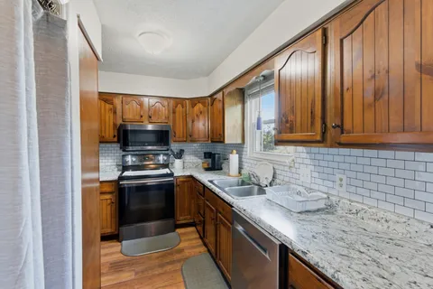 a kitchen with stainless steel appliances granite countertop a sink stove and refrigerator
