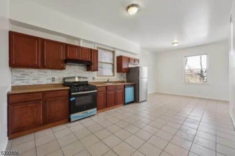235 South 11th Street, Unit 3 Newark, NJ 07107 - Photo 5 of 11 a kitchen with stainless steel appliances granite countertop a stove sink and cabinets