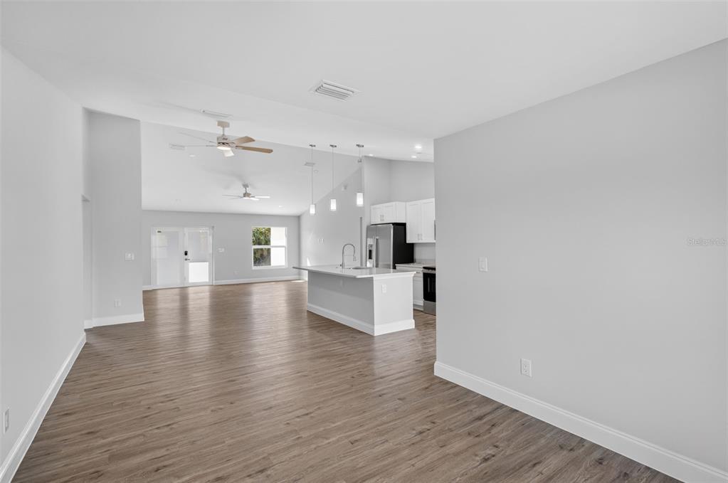 375 Denver Drive Port Charlotte, FL 33954 - Photo 11 of 37 a view of an empty room and kitchen with wooden floor
