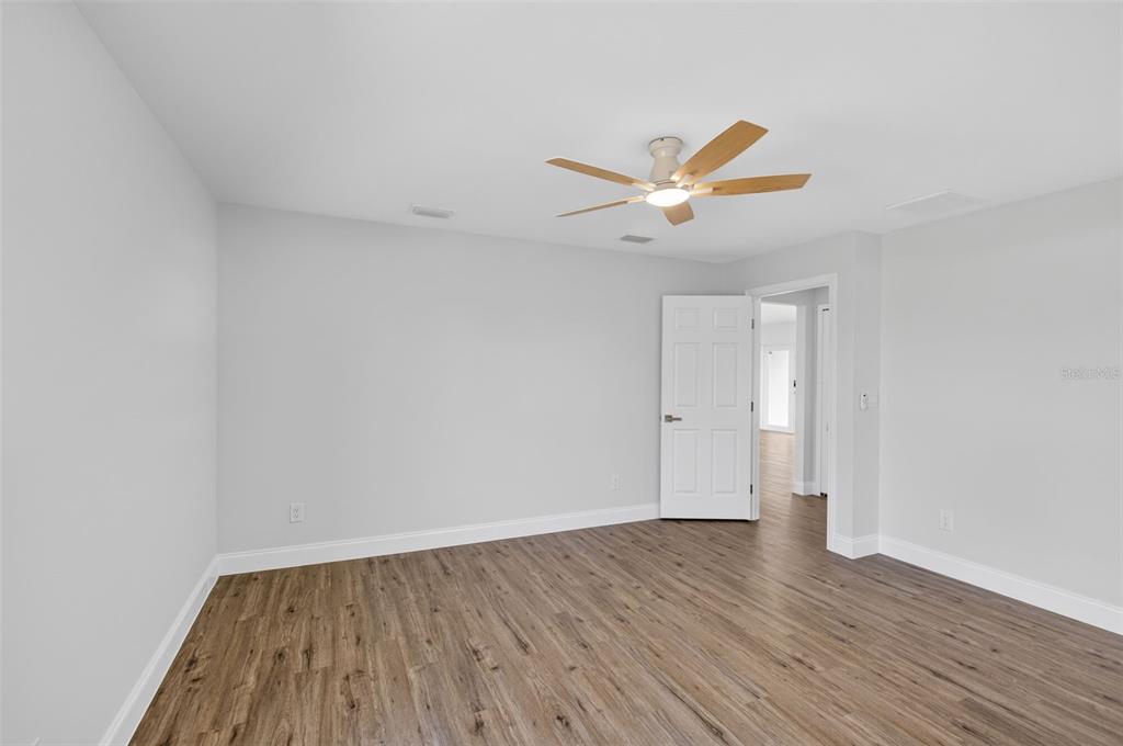 375 Denver Drive Port Charlotte, FL 33954 - Photo 16 of 37 a view of a room with wooden floor and a ceiling fan