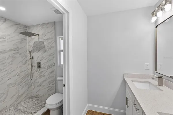 a bathroom with a granite countertop sink toilet and shower