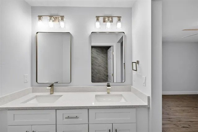 a bathroom with double vanity sinks and a mirror