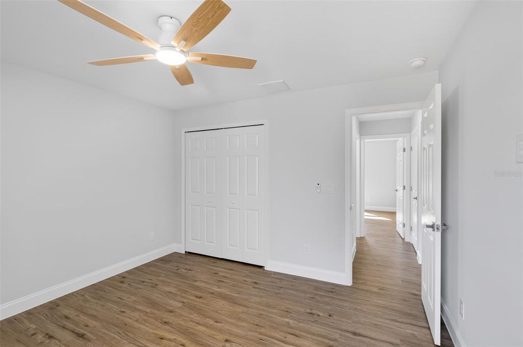 375 Denver Drive Port Charlotte, FL 33954 - Photo 23 of 37 a view of a room with wooden floor and a ceiling fan