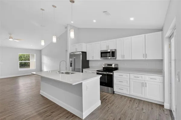 a kitchen with stainless steel appliances a sink stove and microwave