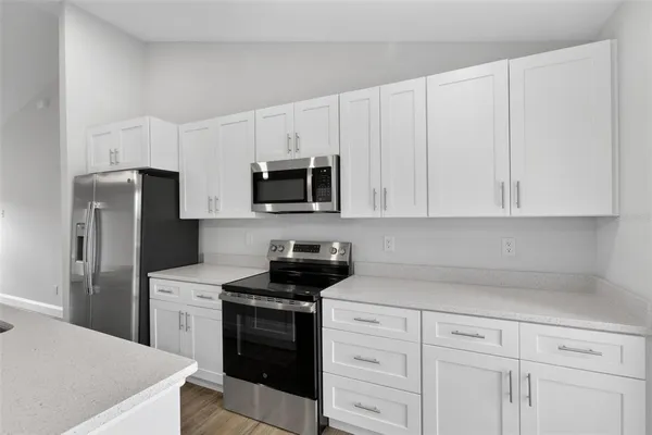 a kitchen with white cabinets and stainless steel appliances