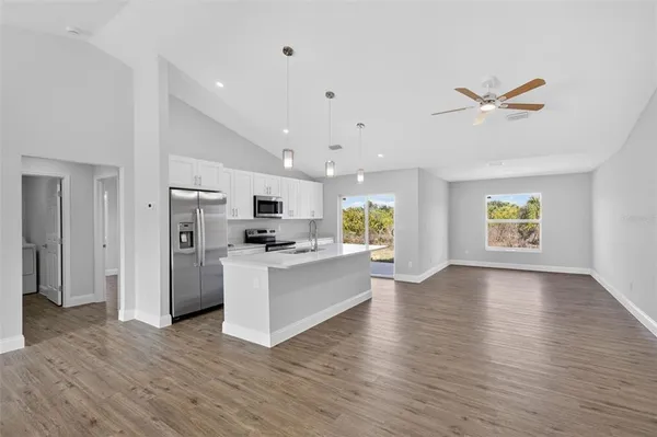 a view of kitchen with stainless steel appliances refrigerator stove microwave and cabinets