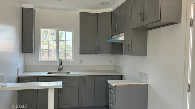 a kitchen with a sink cabinets and a window