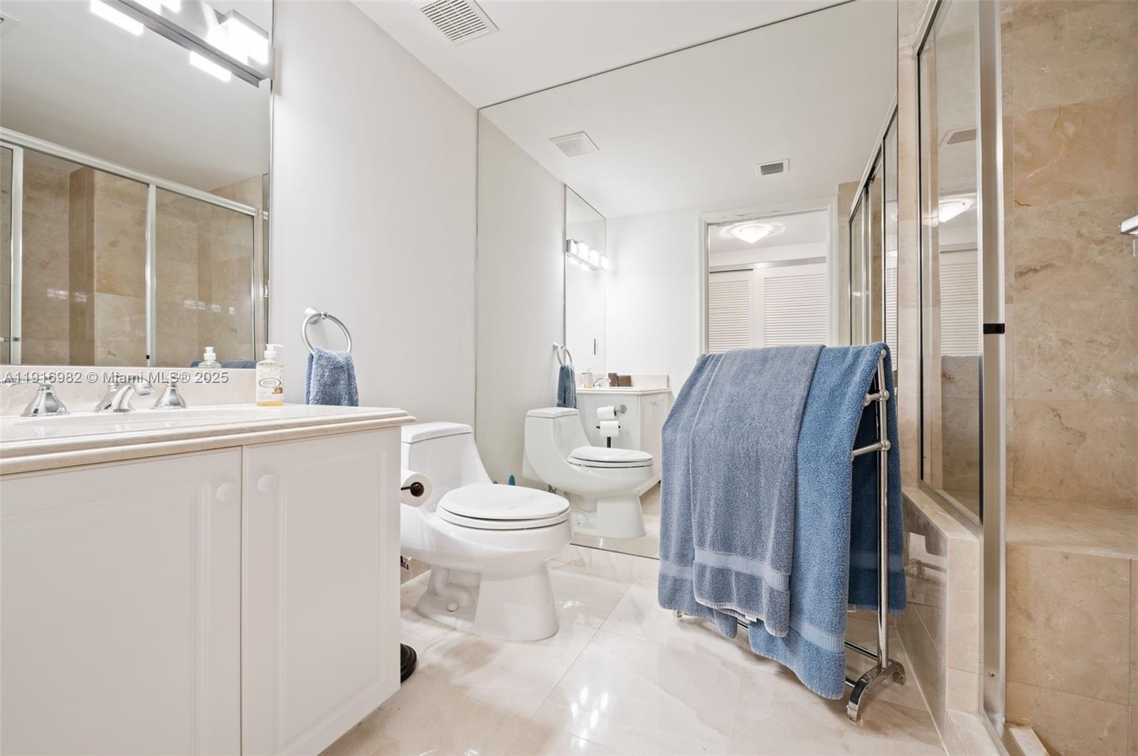 9595 Collins Avenue, Unit N8A Surfside, FL 33154 - Photo 19 of 25 a bathroom with a toilet a sink and a mirror