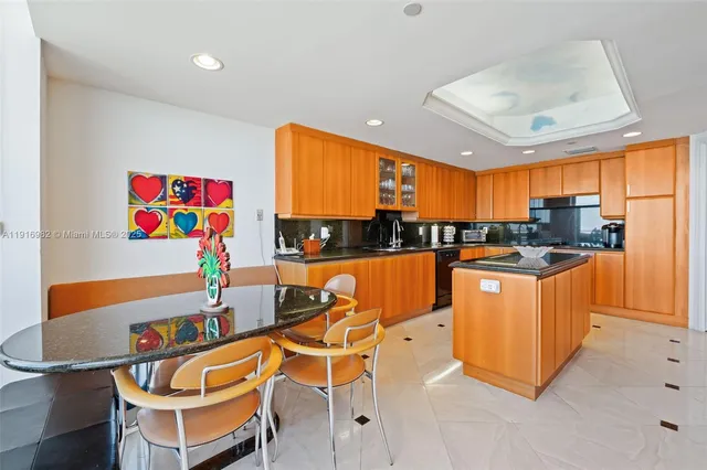a kitchen with stainless steel appliances kitchen island granite countertop a sink and a refrigerator