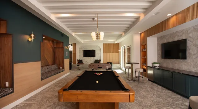 a living room with furniture a flat screen tv and a large window