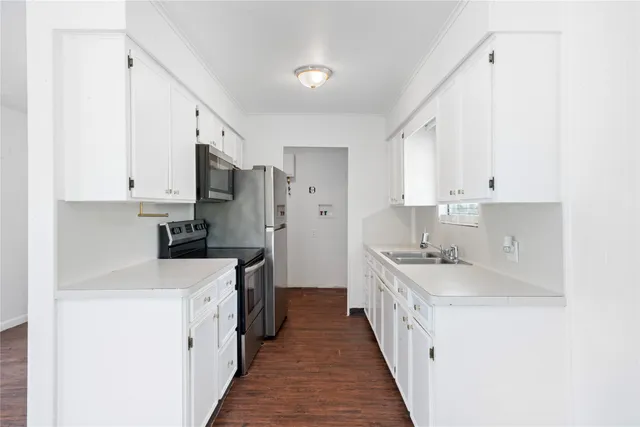 a kitchen with stainless steel appliances a sink stove top oven and cabinets