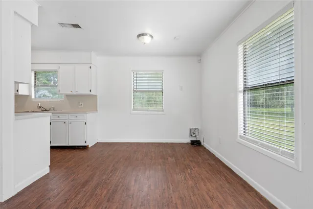 a view of a kitchen with wooden floor and a window