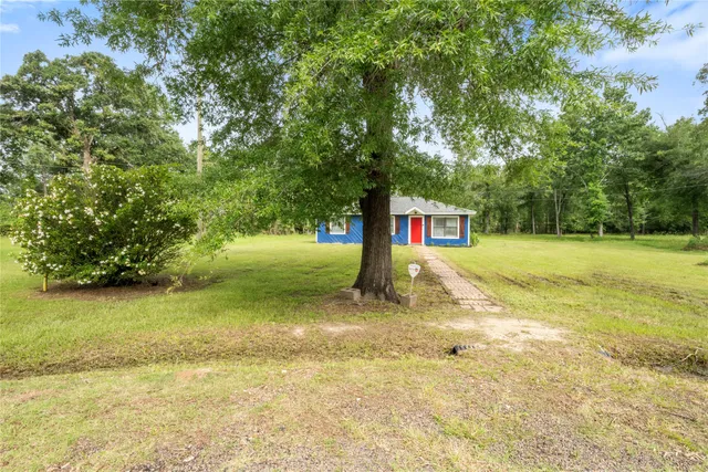 a view of a house with a yard and sitting area