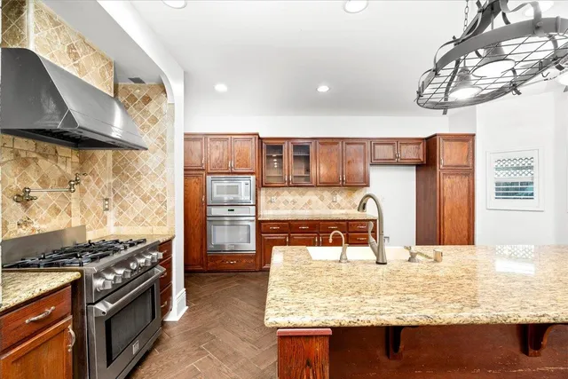 a kitchen with stainless steel appliances granite countertop a sink and a stove