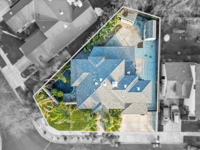 an aerial view of a house with a yard and mountain view in back