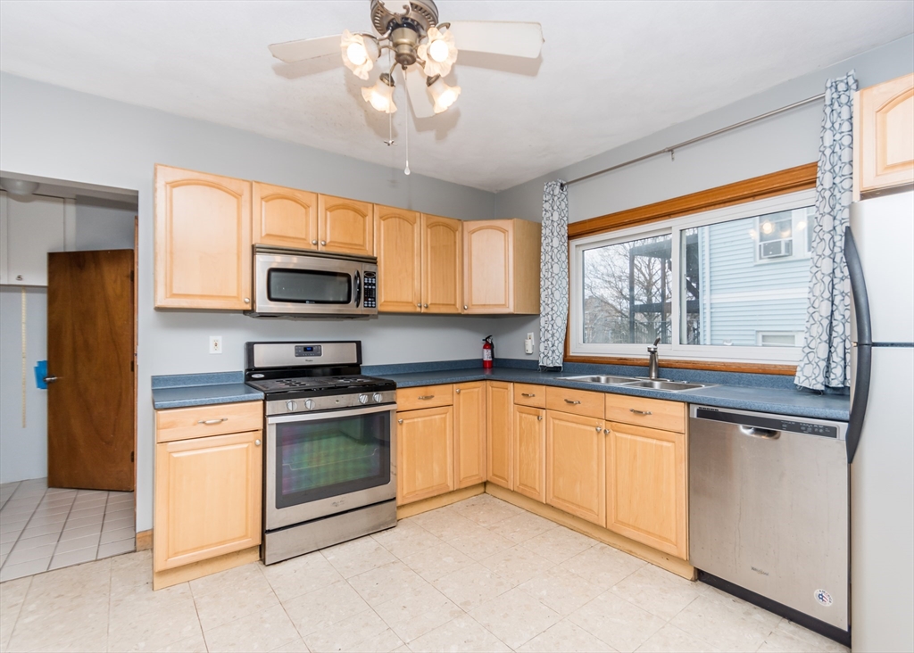 17 Cleveland Avenue, Unit 1 Everett, MA 02149 - Photo 5 of 20 a kitchen with stainless steel appliances granite countertop a stove top oven a sink dishwasher a refrigerator with grey cabinets and wooden floor