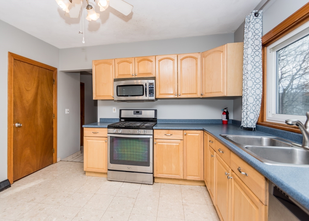 17 Cleveland Avenue, Unit 1 Everett, MA 02149 - Photo 7 of 20 a kitchen with stainless steel appliances granite countertop a sink a stove cabinets and a kitchen island