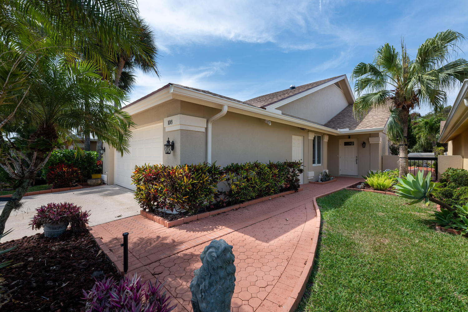 108 Seashore Drive Jupiter, FL 33477 - Photo 2 of 42 a front view of a house with a garden