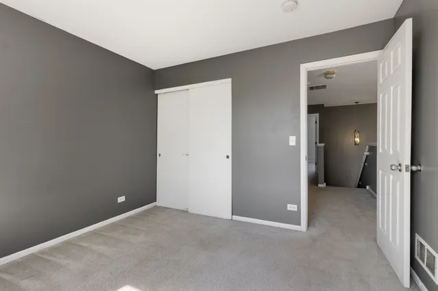 an empty room with closet and a bathroom