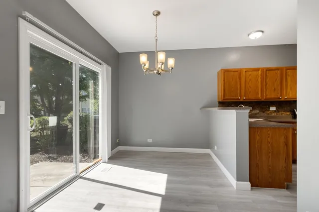 a view of a hallway with wooden floor and a chandelier